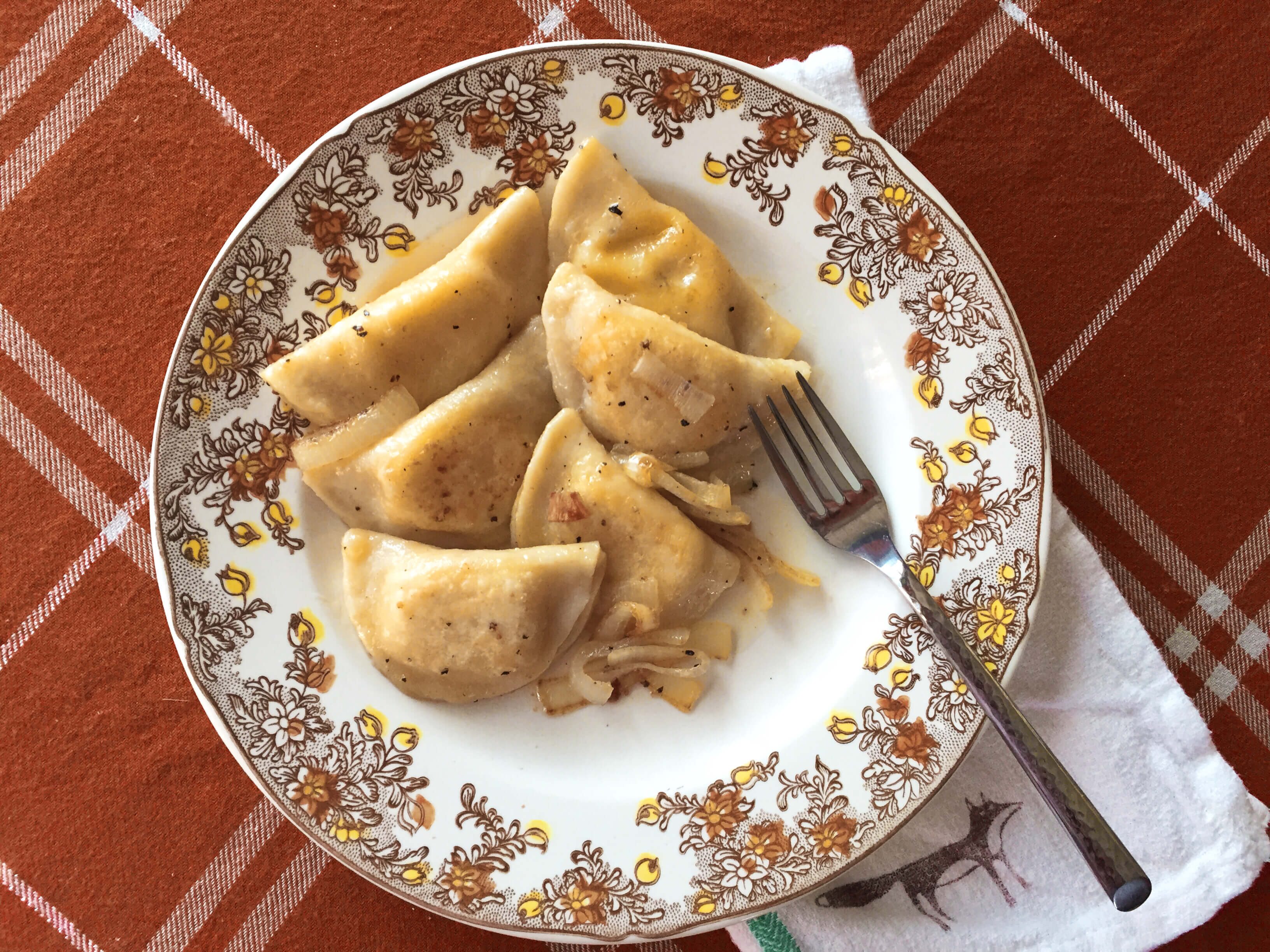 Pierogi on a decorative plate with a metal fork