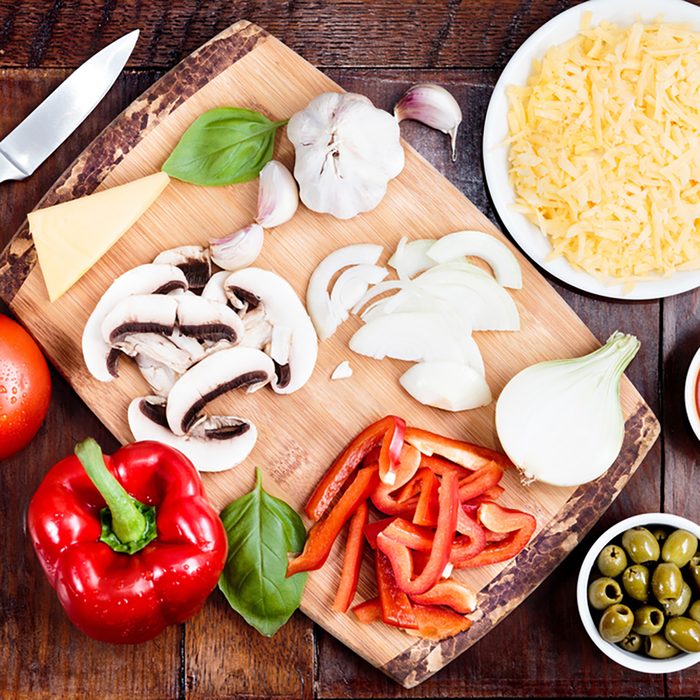 Fresh ingredients for homemade pizza on wooden table