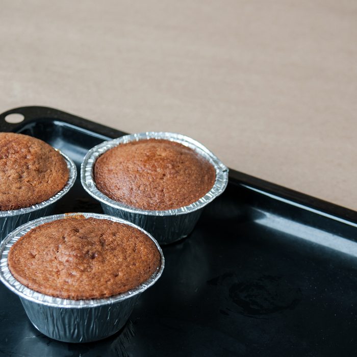 Fresh cupcakes are on a black pan on the table, cookie sheet, cupcake