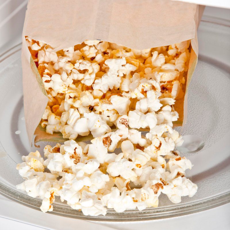 A batch of freshly popped homemade paper bag popcorn in the microwave.