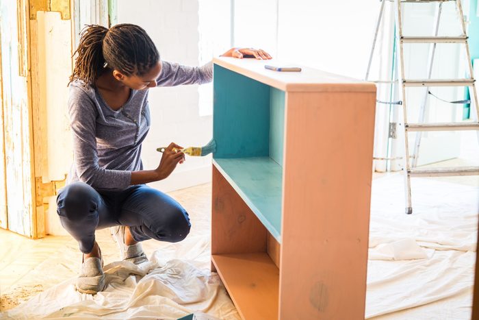 woman Painting A Cabinet- home reneovation remnants