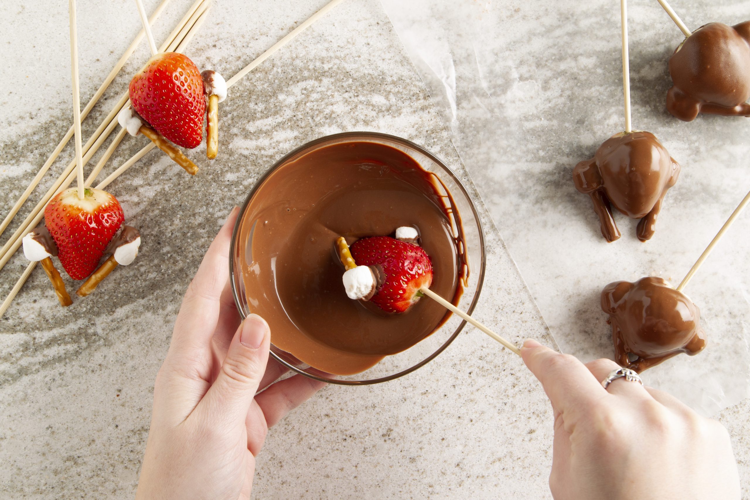 dipping turkey into chocolate for chocolate covered strawberry turkeys