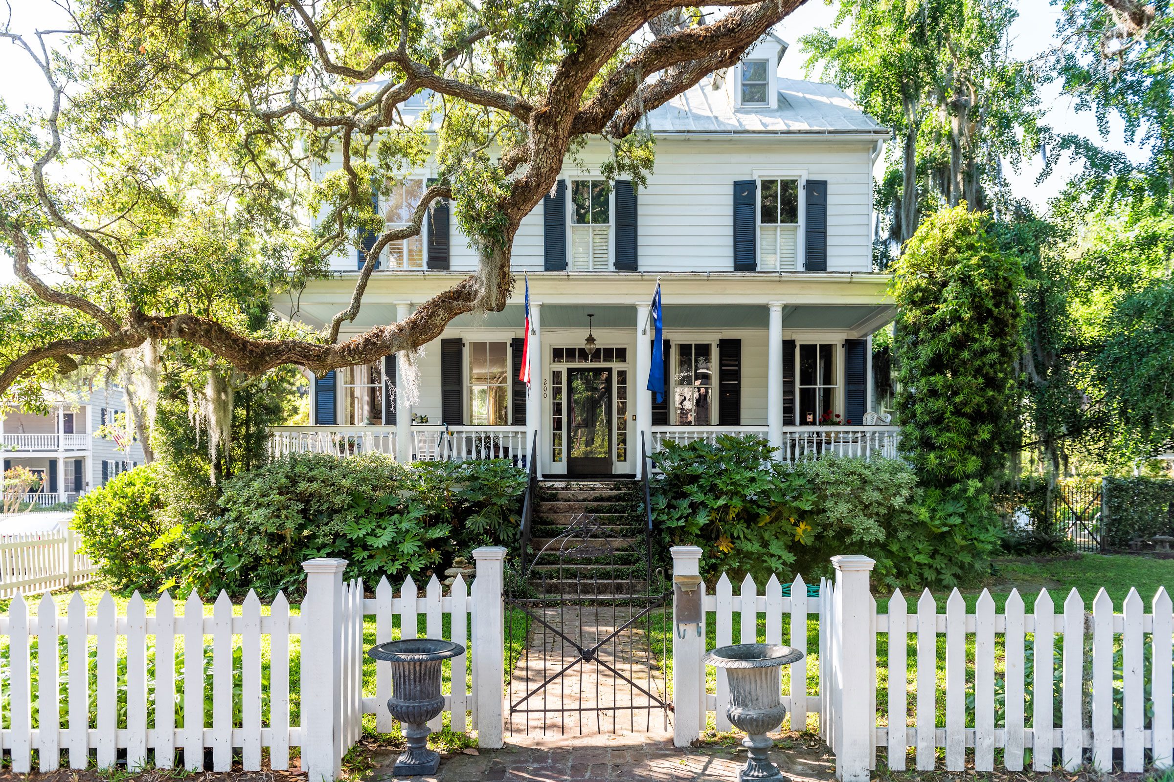 Typical American residential house building in Charleston, South Carolina area with American flag and white picket fence