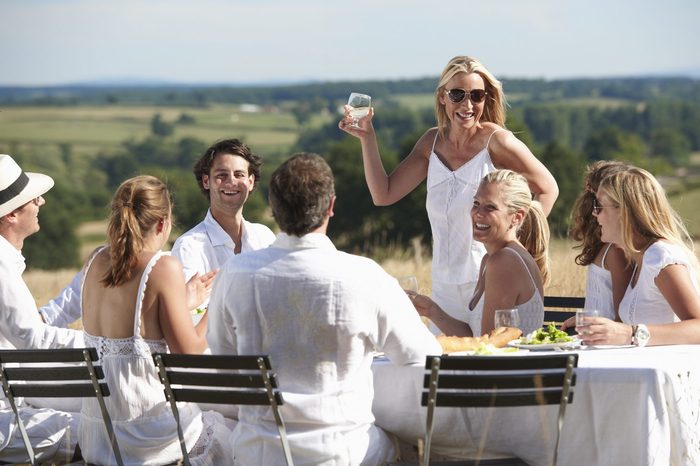 Woman toasting at table outdoors