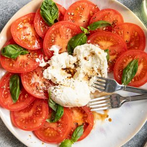 Top view of Burrata Caprese on a plate with a baguette to the side