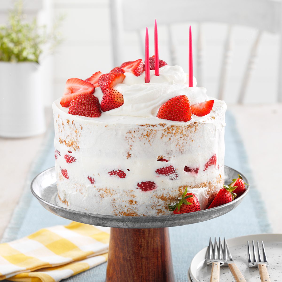 Strawberry cake with white frosting and red birthday candles