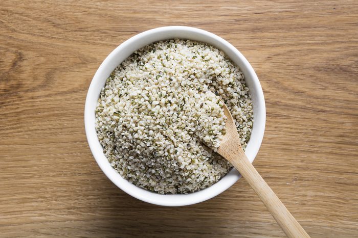 Organic kernels hemp in bowl on wooden board.View from above.