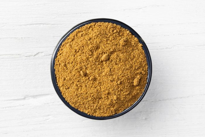 Caraway powder on white wooden background
