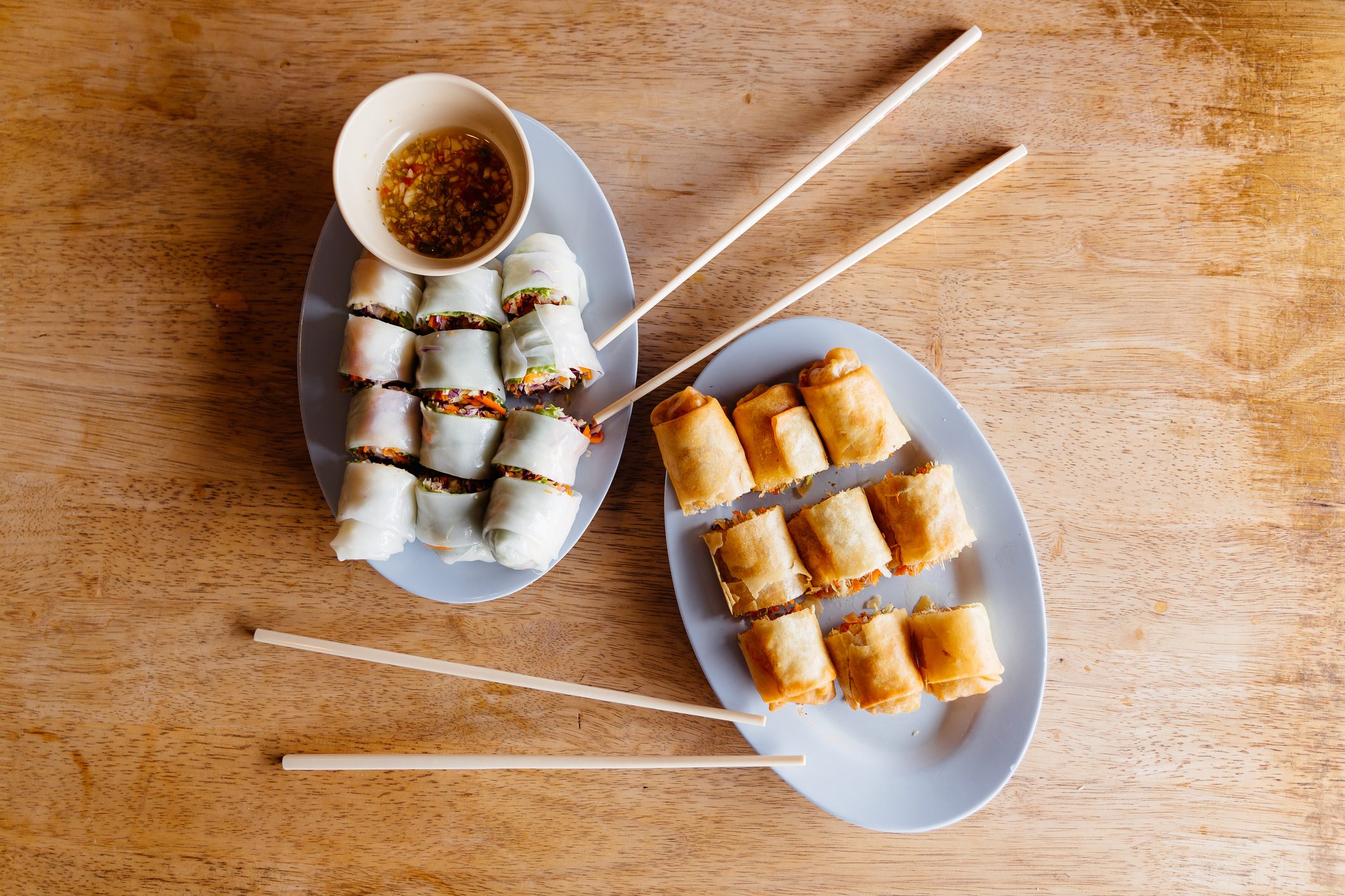 Fresh spring rolls and fried spring rolls on a table, high angle view