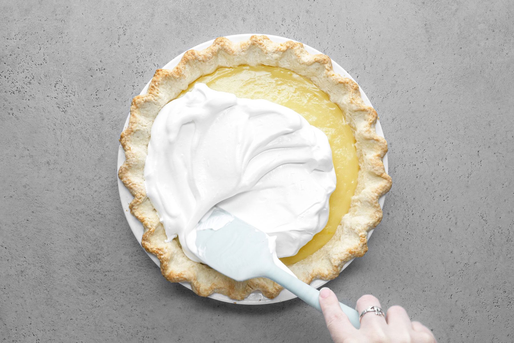 A person Spreading the meringue over the pie