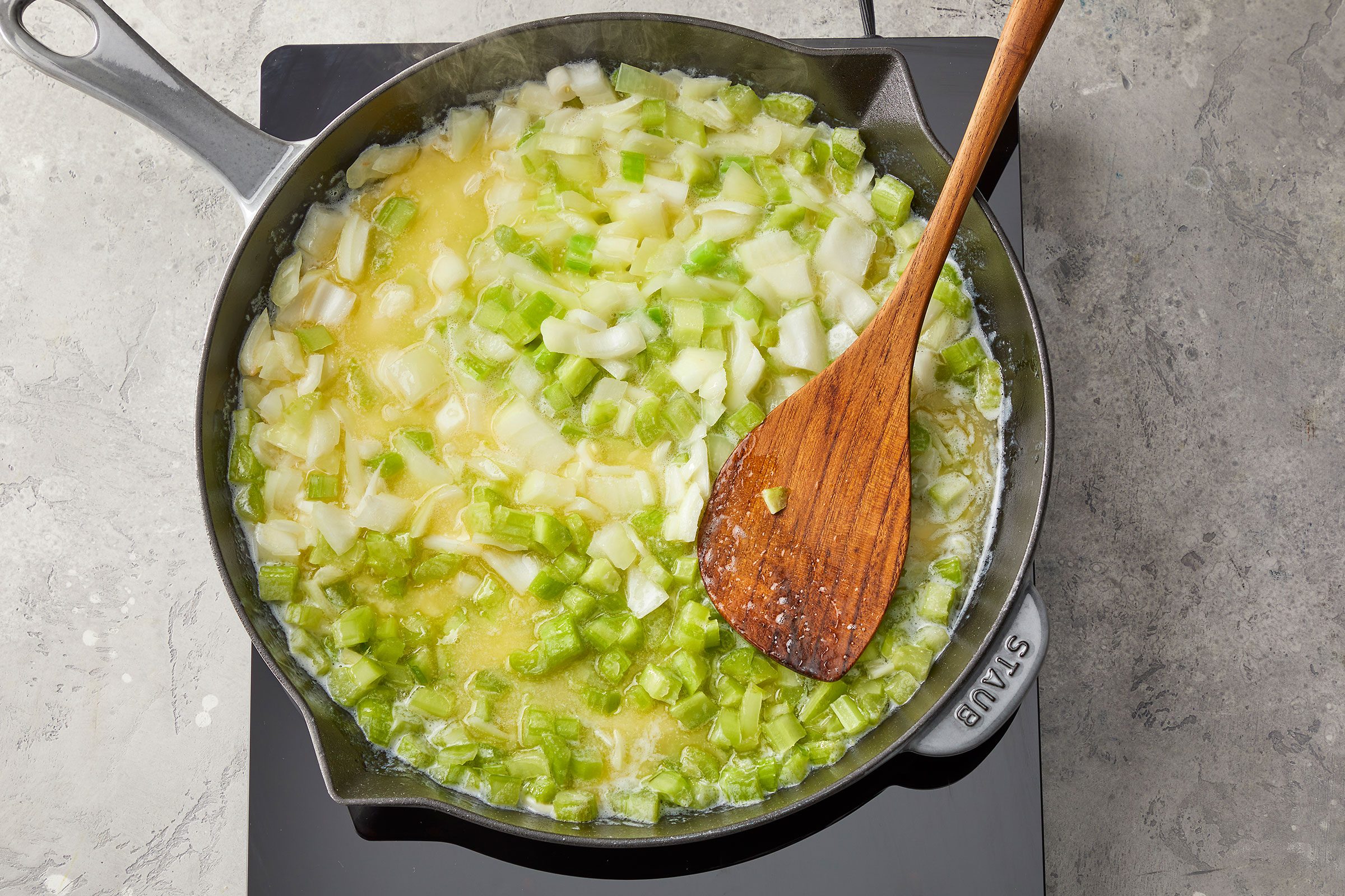 Sauté onion and celery in butter in a large skillet with a wooden ladle