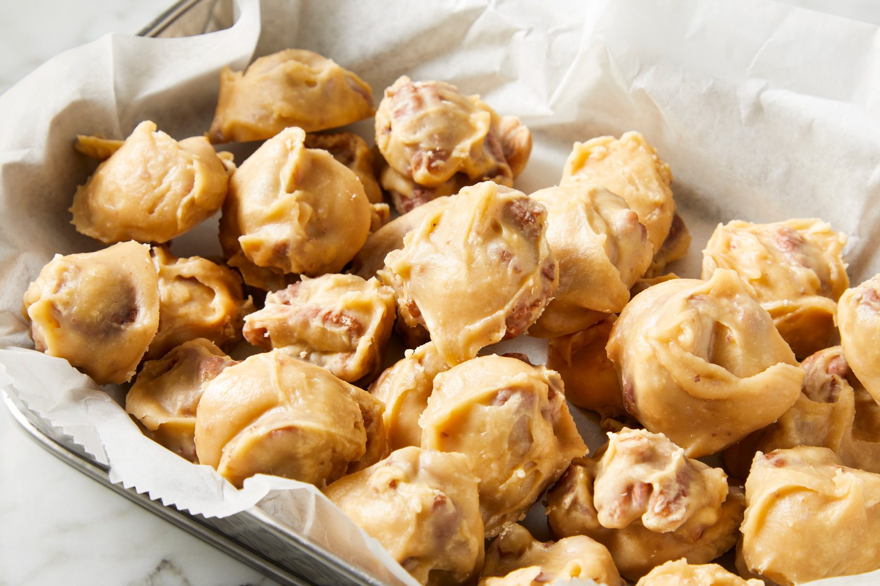 Close up shot of Texas Pecan Pralines; served in a large tray; on marble surface;
